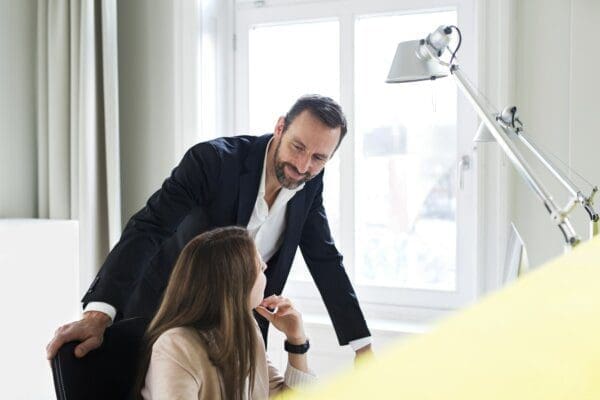 Businessman and employee talking at a desk in an office