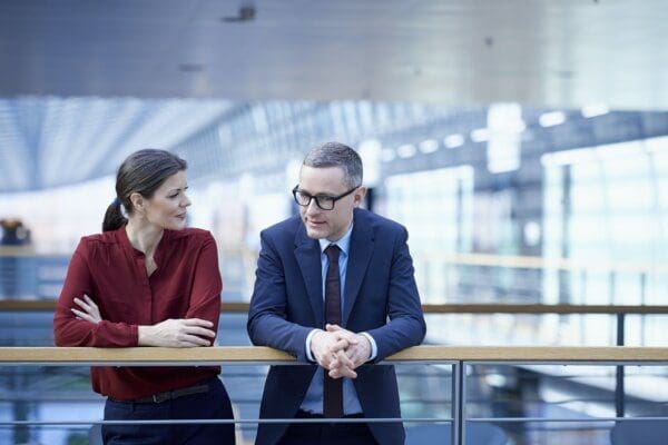 Businesswoman and businessman talking on an office balcony