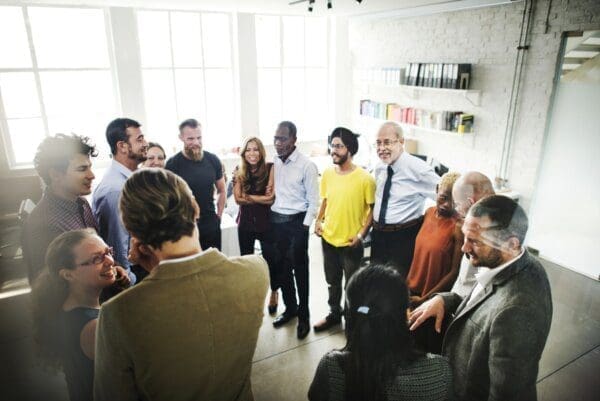 Room of coworkers in a circle communicating with eachother