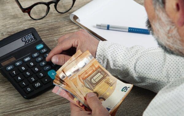 Cost calculating Businessman calculating costs with money in his hand for Distribution Channel Strategy