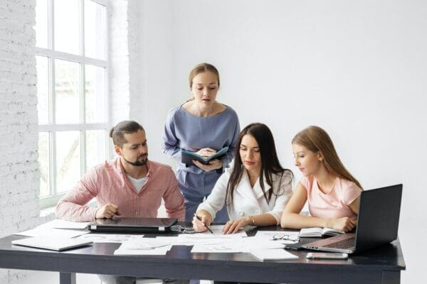 Group of young engaged employees working together at an office desk.