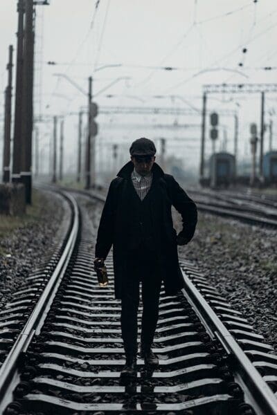 Silhouette of a stylish gangster man with a bottle of whiskey 