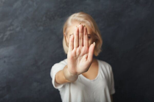 Young woman saying no by showing the palm of her hand