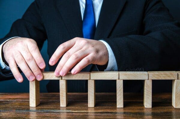 Businessman building a bridge of domino blocks