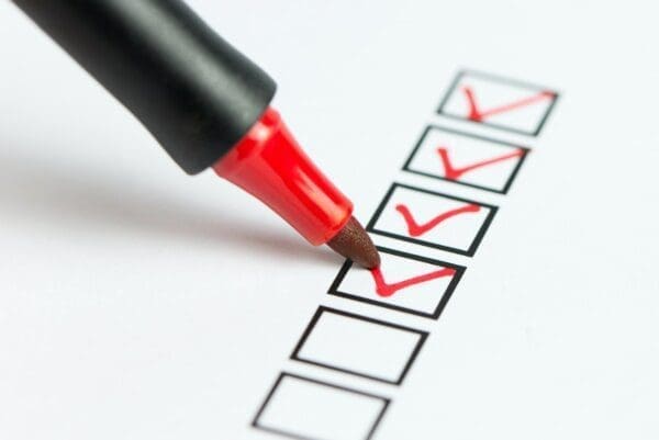 Red marker ticking Checklist boxes on paper