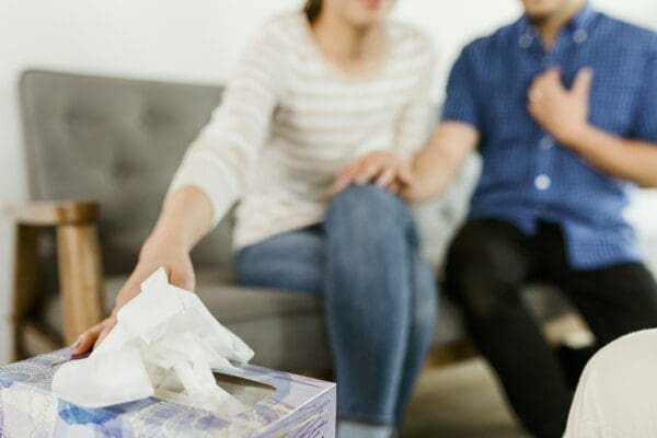 A couple in therapy reaching for tissues