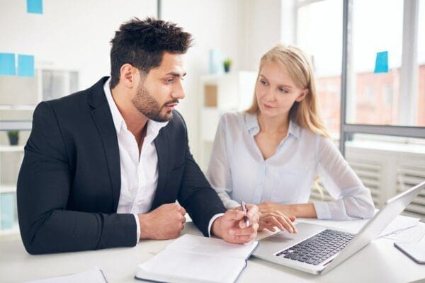 Businessman going through checklist with new employee during induction process