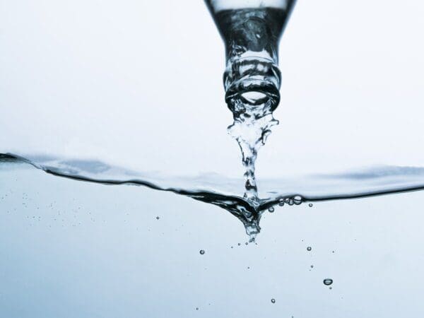 Bottleneck Water being poured from a bottle into a pool of water