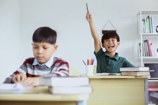 Smart student rising hand in the class shows intelligence