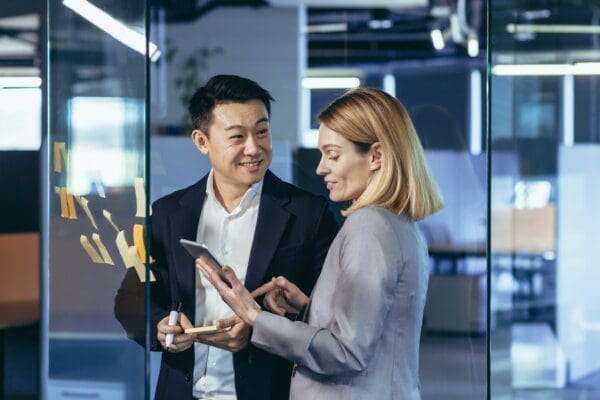 Male and female colleague working together with iPad