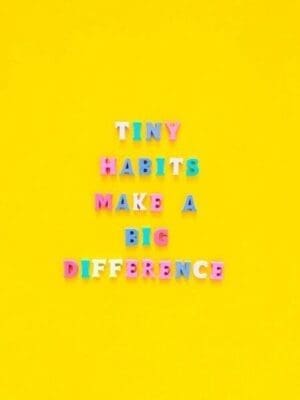 Tiny habits make a big difference written in colourful magnets on yellow background