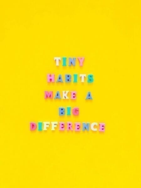 Tiny habits make a big difference written in colourful magnets on yellow background