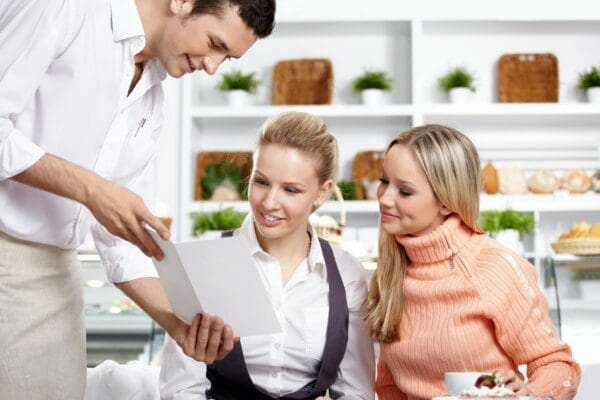 3 employees in a cafe with a visitor 