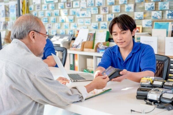 Customer service worker at counter with a customer taking payment