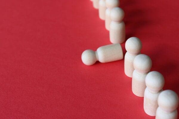 Fallen down white figure from burnout with line of standing white figures on red ground