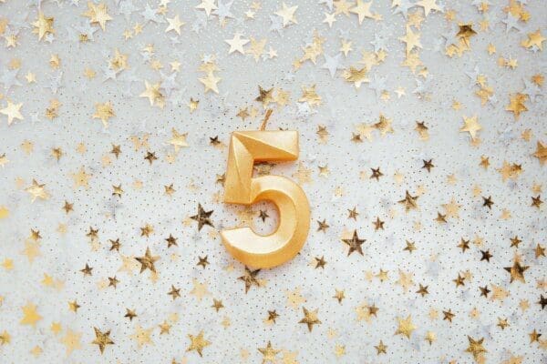 Number five 5 golden celebration birthday candle on Festive star Background