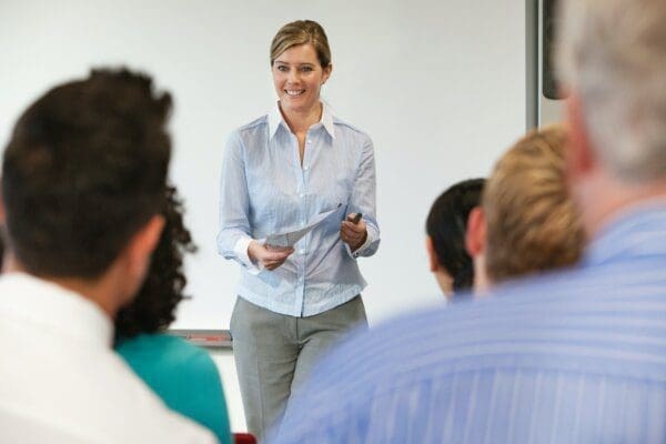 Female coach teaching a training course to businesspeople