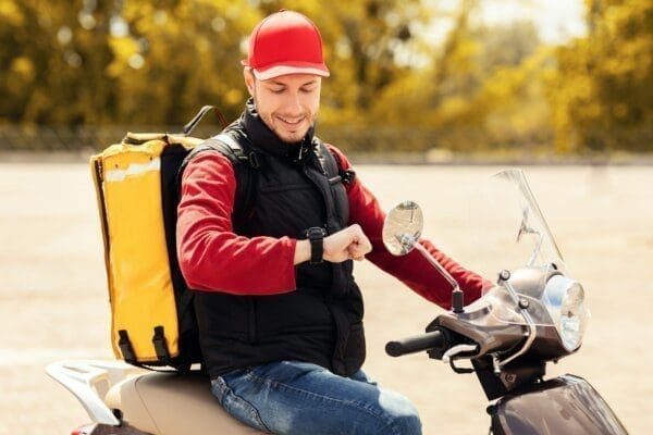 Delivery driver on scooter checking his watch