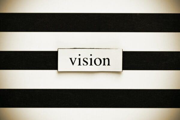 'Vision' written in black and white on a striped background