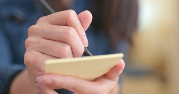 Woman jotting down some note on memo