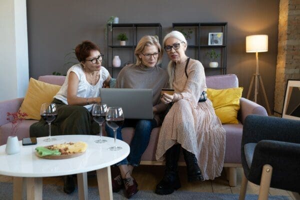 Women on sofa 3 entp women sat on the sofa looking at a laptop and a phone