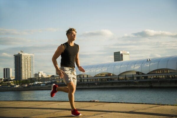 Young man running by the riverside