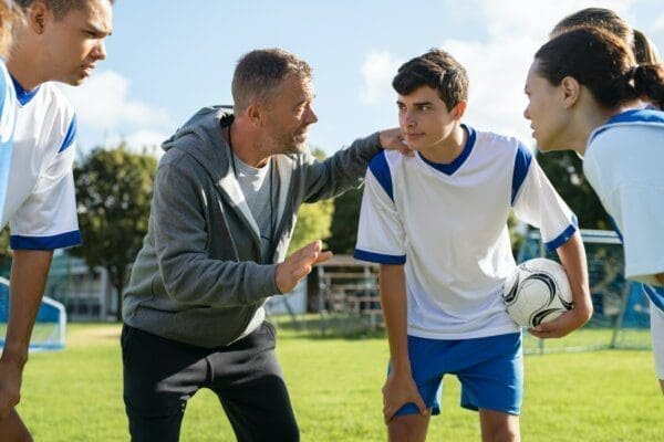 Coach talking to young football team before the match