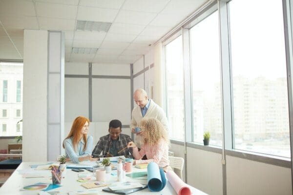 Group of creative designers around a table with creative supplies