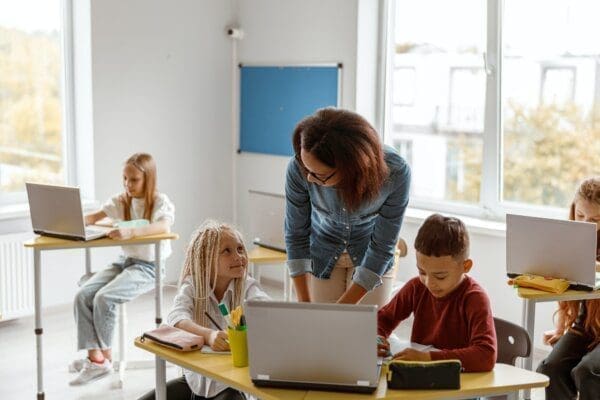 Female teacher explaining the task to schoolchildren