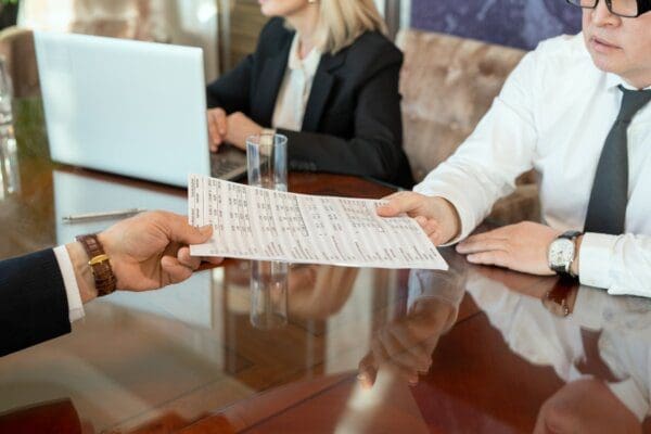 Hands of a businessman passing delegating task to team by passing paper