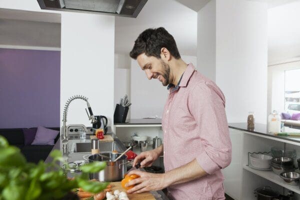 ENFJ Man in the kitchen cutting ingredients to cook