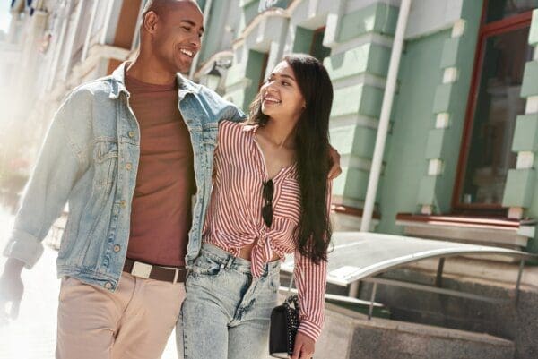 Young couple walking arm in arm along the street