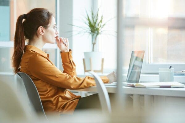 Side view of a woman working at a desk in an office