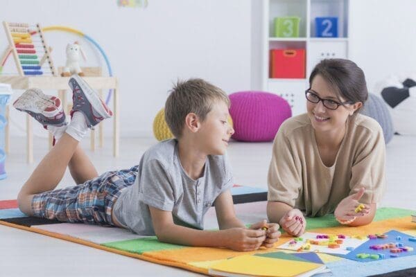 Young teacher laid on the floor with young student