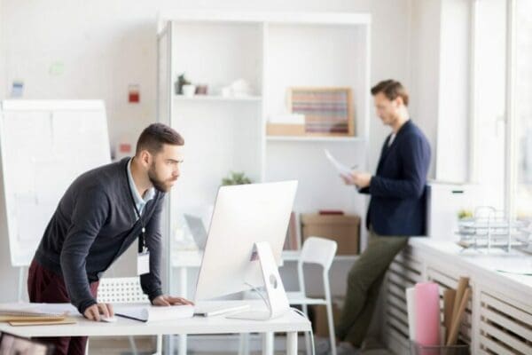 Businessmen in office Two ISTP businessmen in office looking at computer and papers