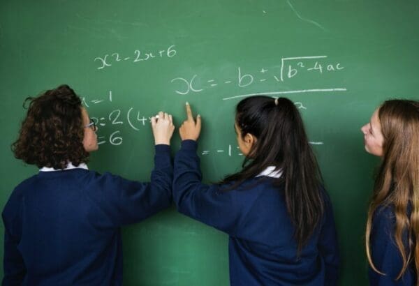Math probleem Female ISTP students solving a math problem on a chalkboard