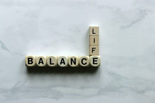 Life Balance spelled with wooden cubes on a white marble surface