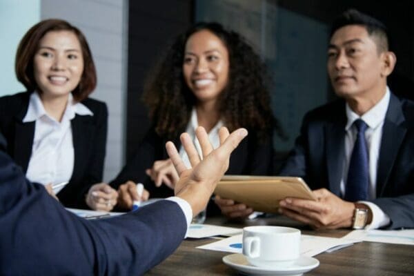 Businesspeople around a table during a meeting showing communication skills