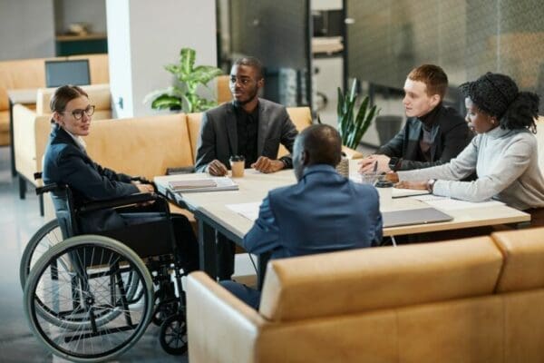 Diversity, Inclusion and Equity Diversity, Inclusion and Equity during a Business Meeting with one person in a wheelchair and different races and genders