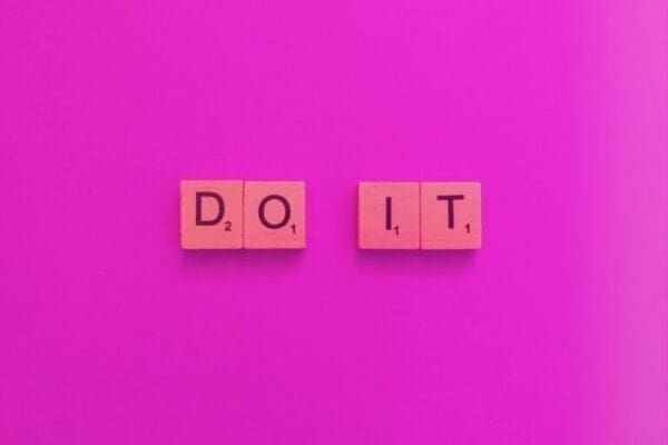 Do it spelled with wooden cubes on pink background