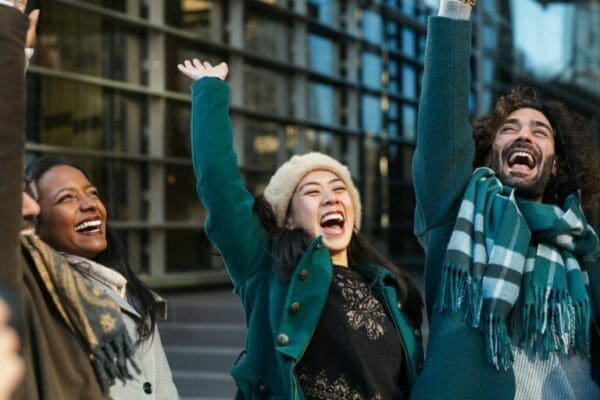 Colleagues with hands in the air celebrating success in city street