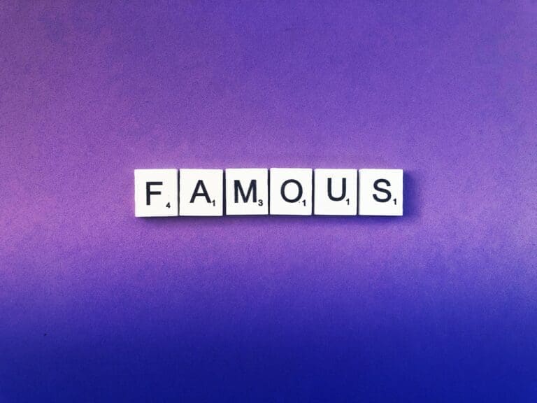 famous Famous spelled with white word scramble cubes on purple background