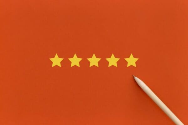 Five Stars Pen pointing to five 5 stars on orange background