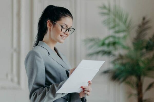 laywer female ESTP lawyer dressed in a grey suit and glasses while writing on a paper