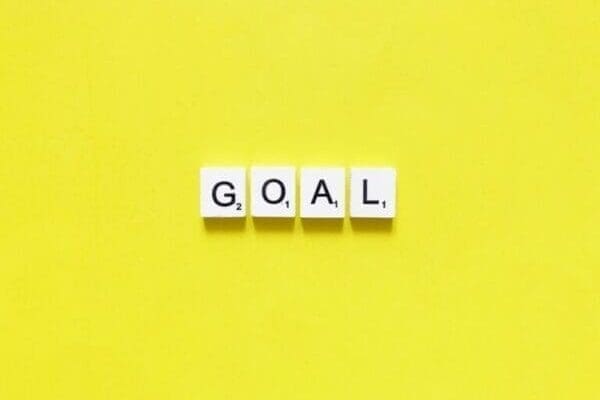 goals Goal spelt with white word scramble cubes on yellow background