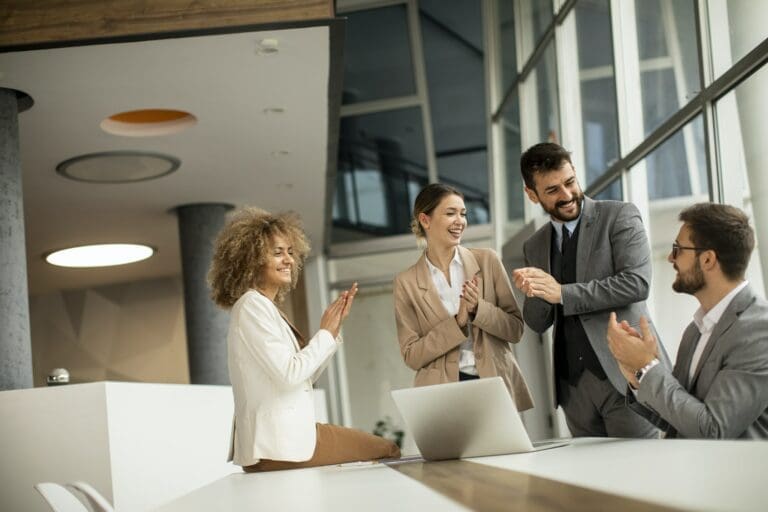 businesspeople group of strategic leaders conversing in an open office and clapping hands