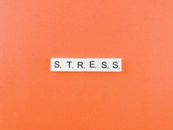 Stress stress spelled with white word scramble tiles on peach background