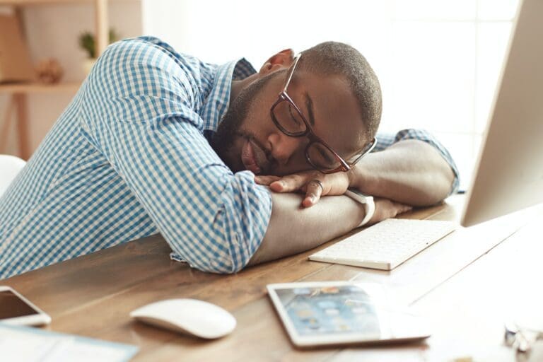 sleeping Male worker sleeping at his office desk behind his computer
