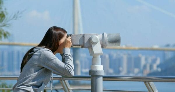 See Strategic leader looking through a binocular to see in front of her