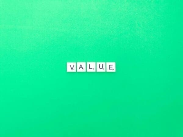 Value Value spelt with white word scramble cubes on light green background